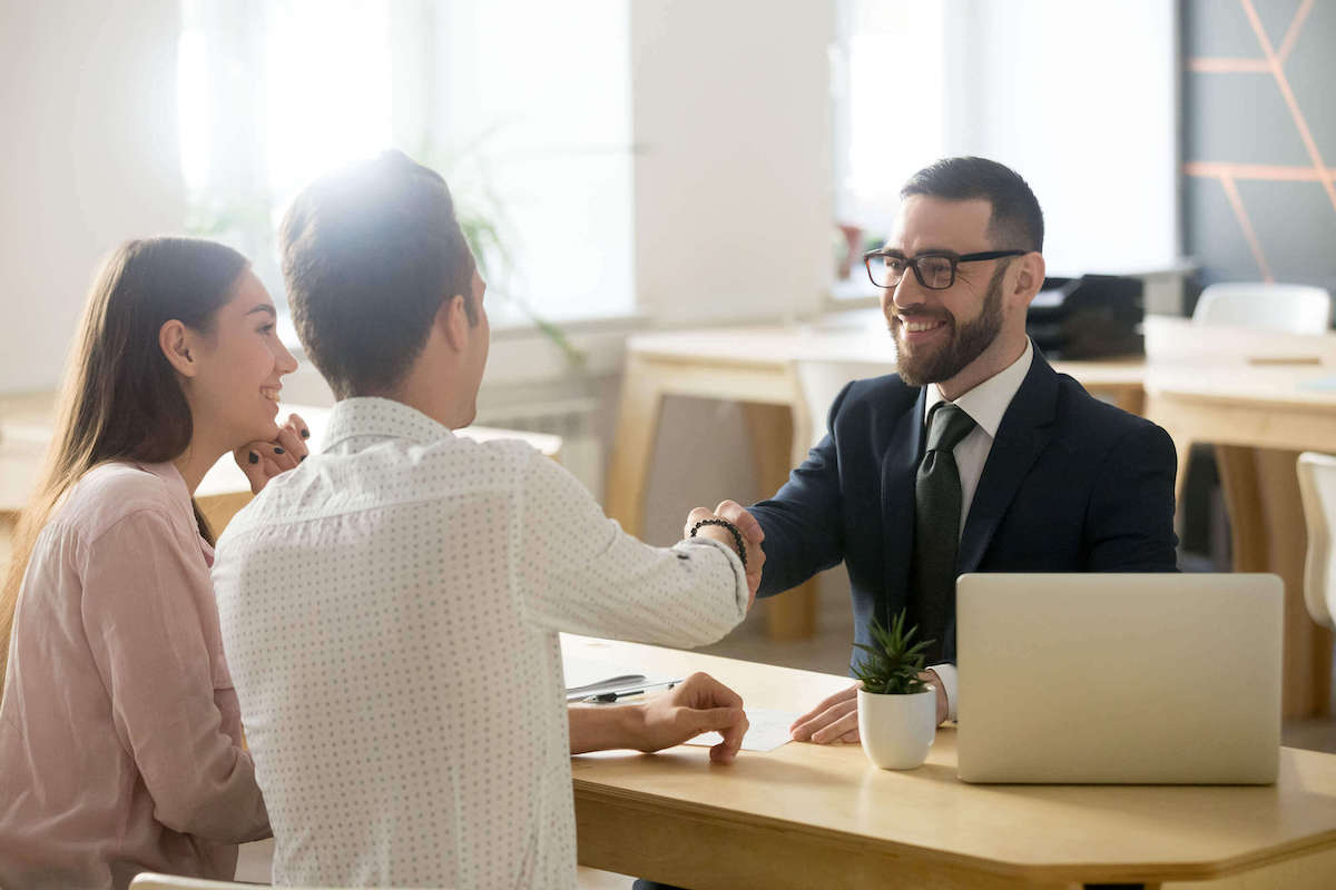 Business professional shaking hands with clients in a modern office setting, symbolizing the benefits of streamlined document automation and improved customer engagement with Experlogix