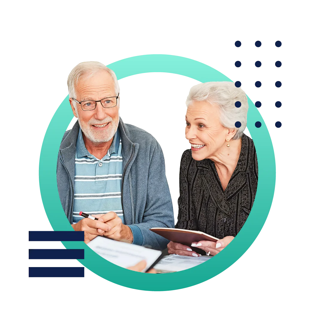 A senior couple smiling and meeting with an insurance agent sitting at a desk.