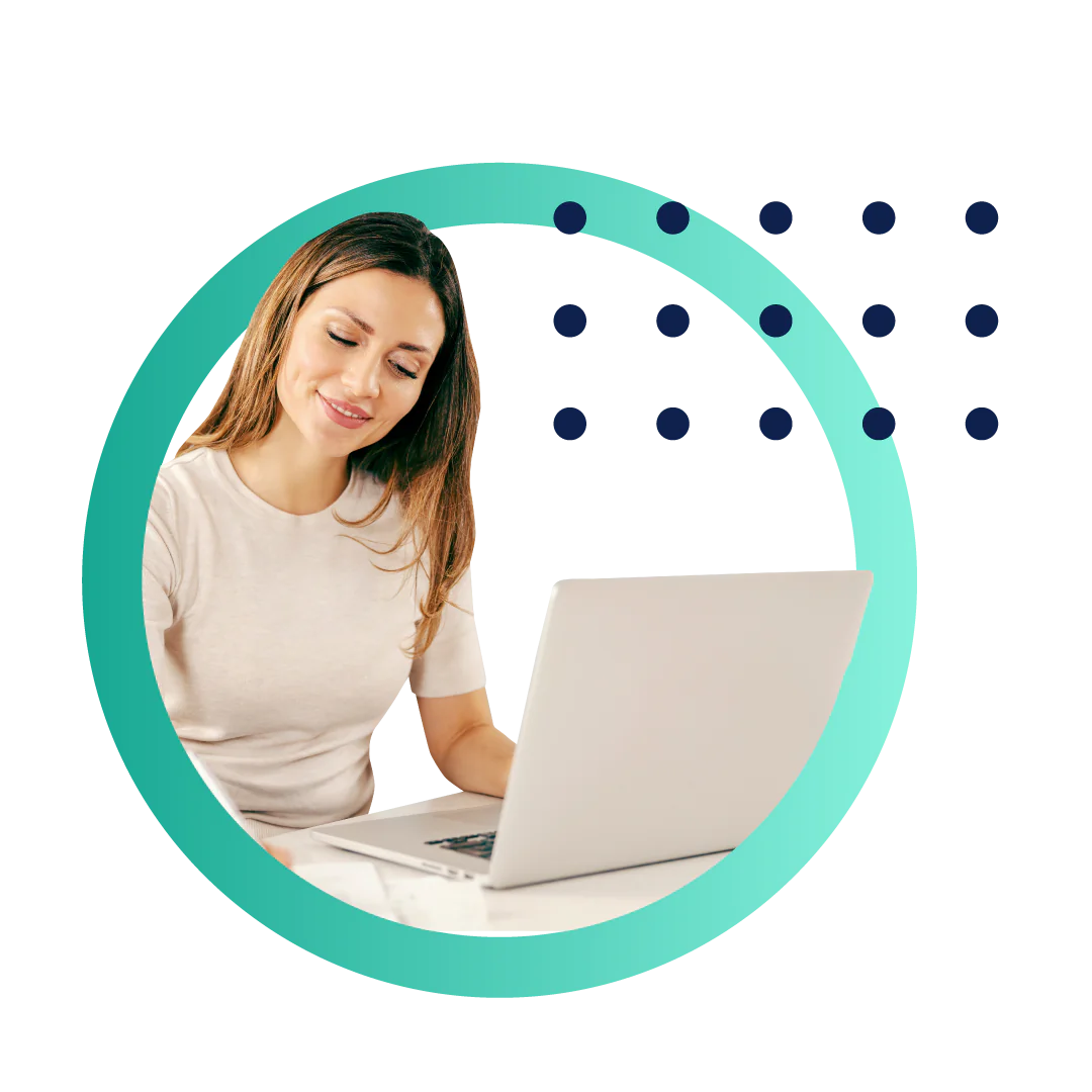 A business woman smiling and writing on a document while working at her desk on a laptop, all placed inside of a designed green circle.