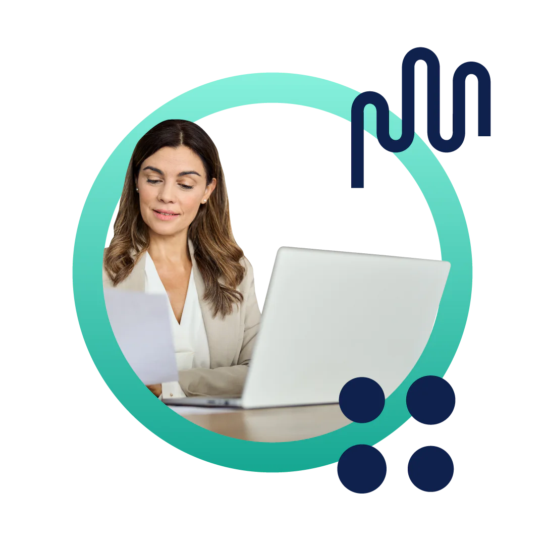 A business woman in a tan suit reading a document and sitting at her desk in front of a computer, inside of a designed green circle.