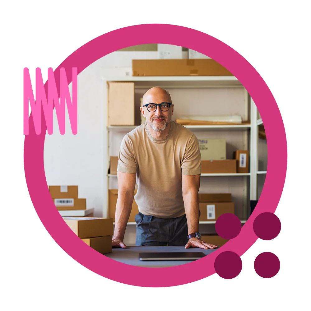 A businessman using his laptop for B2B ecommerce solutions including order punchout in a warehouse with boxes.